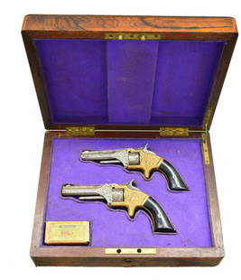 CIVIL WAR ERA CASED PAIR ENGRAVED SMITH & WESSON: OLD MODEL ONE REVOLVERS. Cal. 22 S. S# 31607 & 42103. Bbls. 3 3/16". Standard configuration w/ brass frames, ebony grips, one line address on top of ribbed bbls. About 80% of surfaces are engraved en