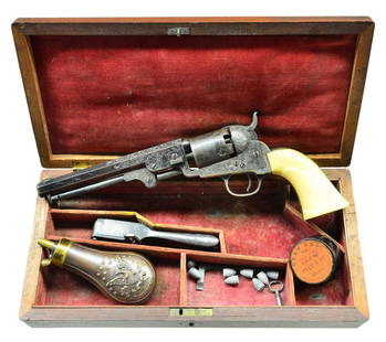 OUTSTANDING CASED COLT 1849 POCKET MODEL FACTORY: ENGRAVED REVOLVER. Cal. 31. S# 124533. Bbl. 6" octagon with dovetail mounted brass blade front sight. Top flat has engraved "Saml Colt" marking in the old English style. Five shot round cylinder with