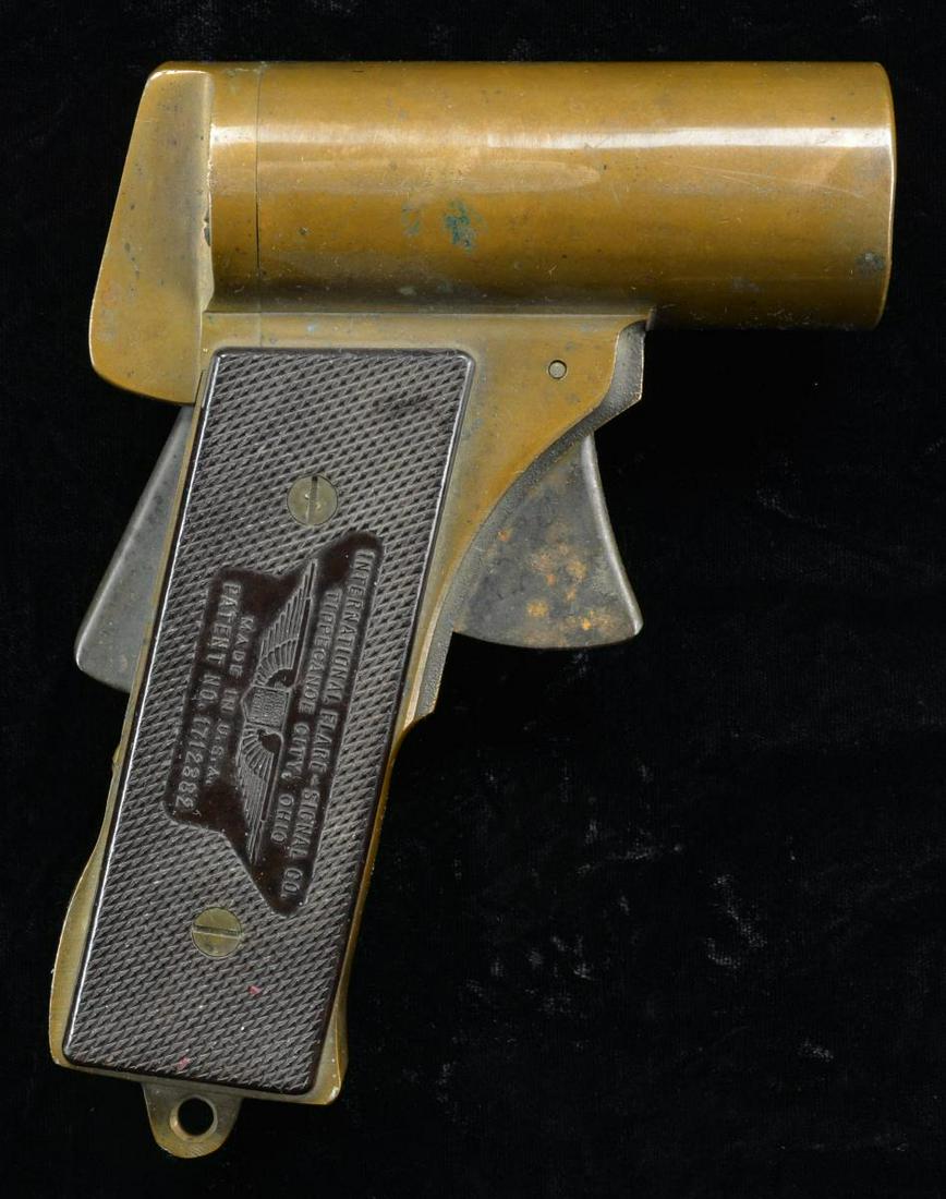 WWII US INTERNATIONAL FLARE-SIGNAL PYROTECHNIC: M2 FLARE PISTOL. Cal. 37mm. S# 34969. Bbl. 2 1/4" smoothbore. Brass construction. Grip safety. 2 Piece brown bakelite grips. CONDITION: good overall w/ mustard patina on brass w/ areas of staining & l