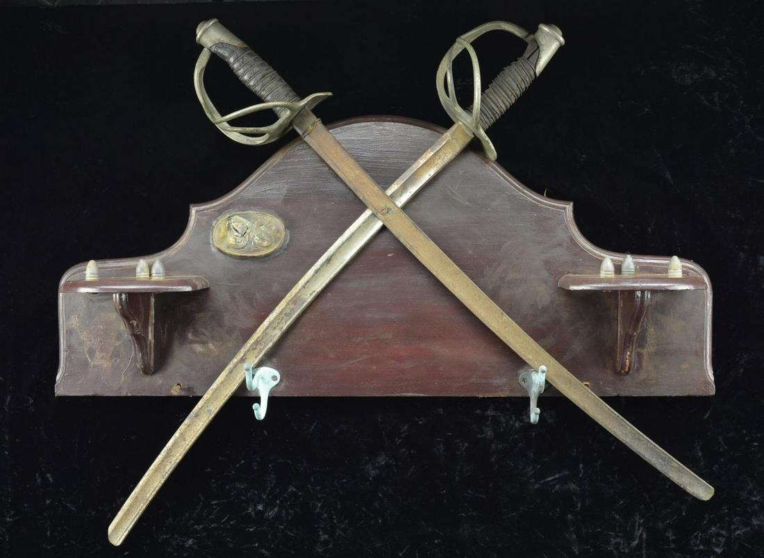 CIVIL WAR MILITARIA DECORATE WALL HAT RACK.: 30" x 13" wooden wall rack w/ 2 hooks for hats. Rack is decorated w/ a "US" belt buckle that has been stuck w/ bullet, 2 cut M1860 Cavalry sabers & 6 Minie balls screws into the rack. CONDITION: rack 
