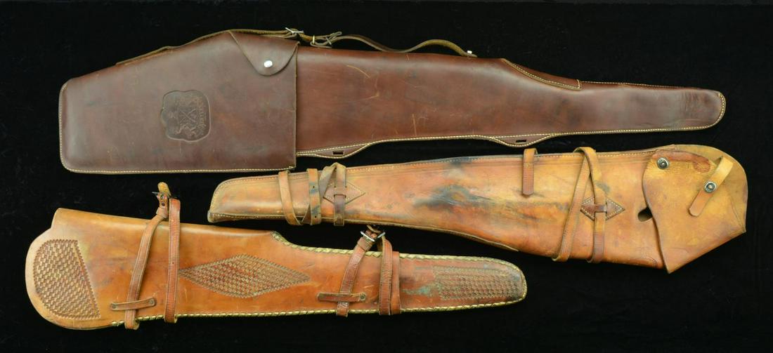 3 BROWN LEATHER RIFLE SCABBARDS.: 1) THE SCHOELLKOPF CO DALLAS, TEXAS JUMBO RIFLE SCABBARD. Approx. 38” overall w/ 2 leather straps & snap & dot retention. CONDITION: good, intact w/ dark black patina throughout, scuffs & cracki