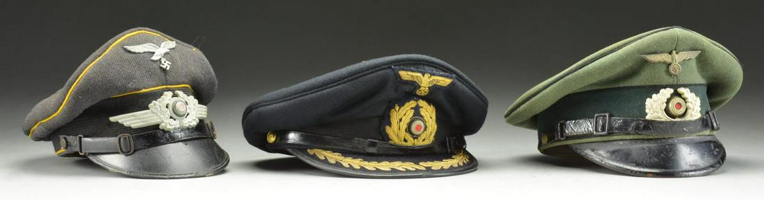 3 WWII GERMAN VISOR CAPS.: 1) LUFTWAFFE. This enlisted visor cap has a gray crown with a black band. It is piped in yellow throughout. There is a zinc Luftwaffe eagle at the front of the crown along with a zinc winged wreath &