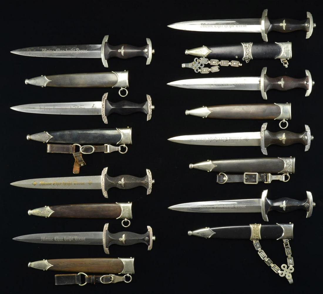 8 REPRODUCTION WWII GERMAN SS DAGGERS.: This group of reproduction daggers includes 1 chained SS dagger with oak leaf engraved throat & tip and a "BOKER" maker’s mark. / 1 Chained SS dagger with RZM marks on the blade. / 1 SS honor dagger
