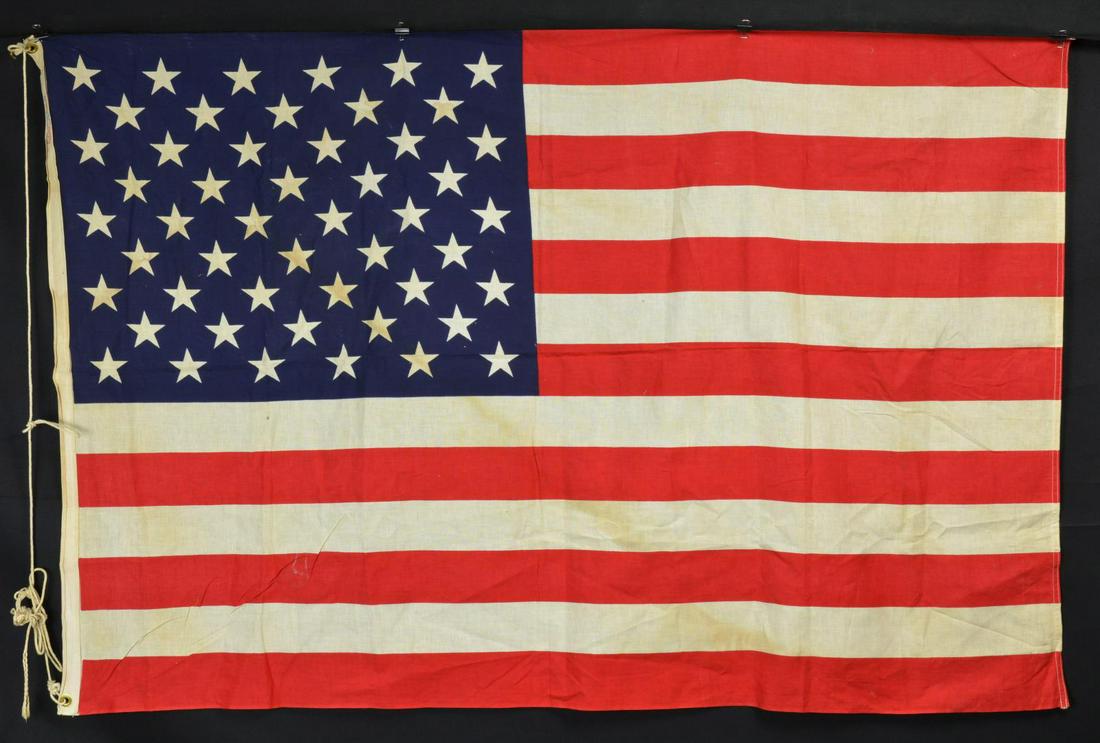 GROUP OF FIVE AMERICAN FLAGS.: One 13 star small ensign and four 50-star flags. Two of the 50 star flags are regulation military colors 3x4", one with 1969 dated Philadelphia quartermaster depot label in sleeve, one flag is a varia