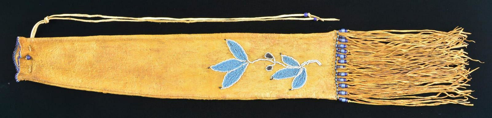 FINE NATIVE AMERICAN BEADED PIPE BAG.: 32” overall with rawhide fringe, navy blue, sky blue, light blue sinew sewn beads in floral design, beaded edges top & bottom, larger blue beads on fringe. CONDITION: fine overall. supple leathe