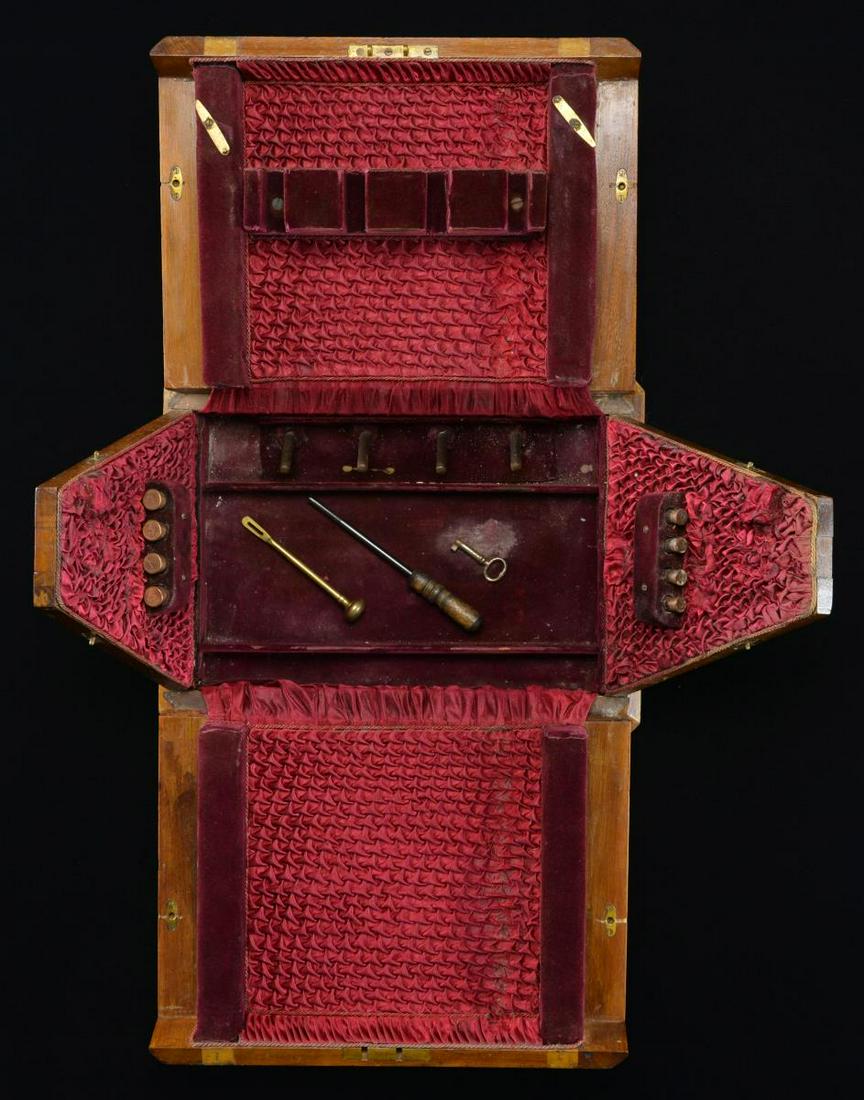 ANTIQUE WALNUT TRIANGULAR REVOLVER TRAVEL CASE.: 12" x 9.5" x 9" walnut travel case w/ brass hinges & latches. Top of case has personalized plaque engraved "LCB". Case opens blossoms to reveal a red silk & corduroy interior. Case appears to hold 4 r