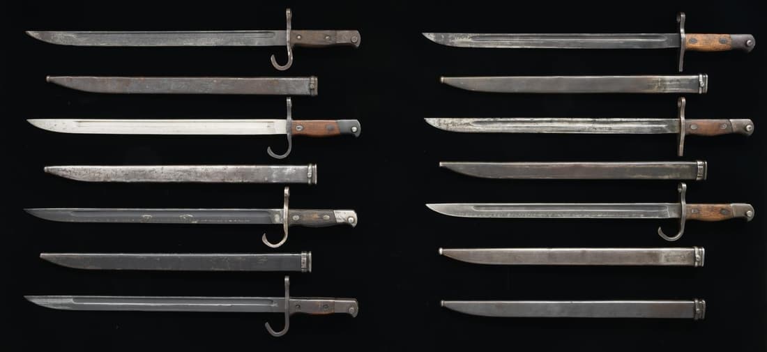 GROUP OF 7 JAPANESE TYPE 30 BAYONETS.: 1) Manufactured at the Nagoya arsenal. Nagoya arsenal insignia on right side of ricasso and number "34559" on bottom of the pommel. Blued blade with hooked quillon, contoured birds head pommel, and st