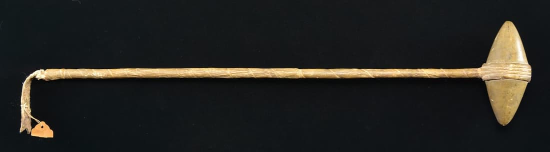 NATIVE AMERICAN PLAINS "SKULL CRACKER" WAR CLUB.: 26" overall, 5.5" double pointed central grooved polished stone head that is well patinaed, securely attached to a wooden handle with rawhide wrapping as is the handle. Mr. Mattox's collection tag sta