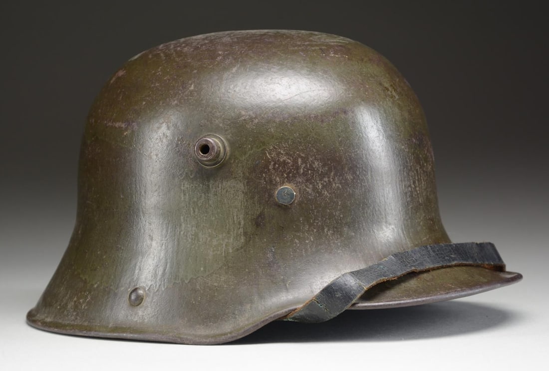 WWI GERMAN M1916/17 HELMET.: Helmet has a dark field green paint and shows residue of a decal on each side. The inside left of the helmet has a partially legible stamp that appears to read ?3F.6?. 3-Pad brown leather liner and co