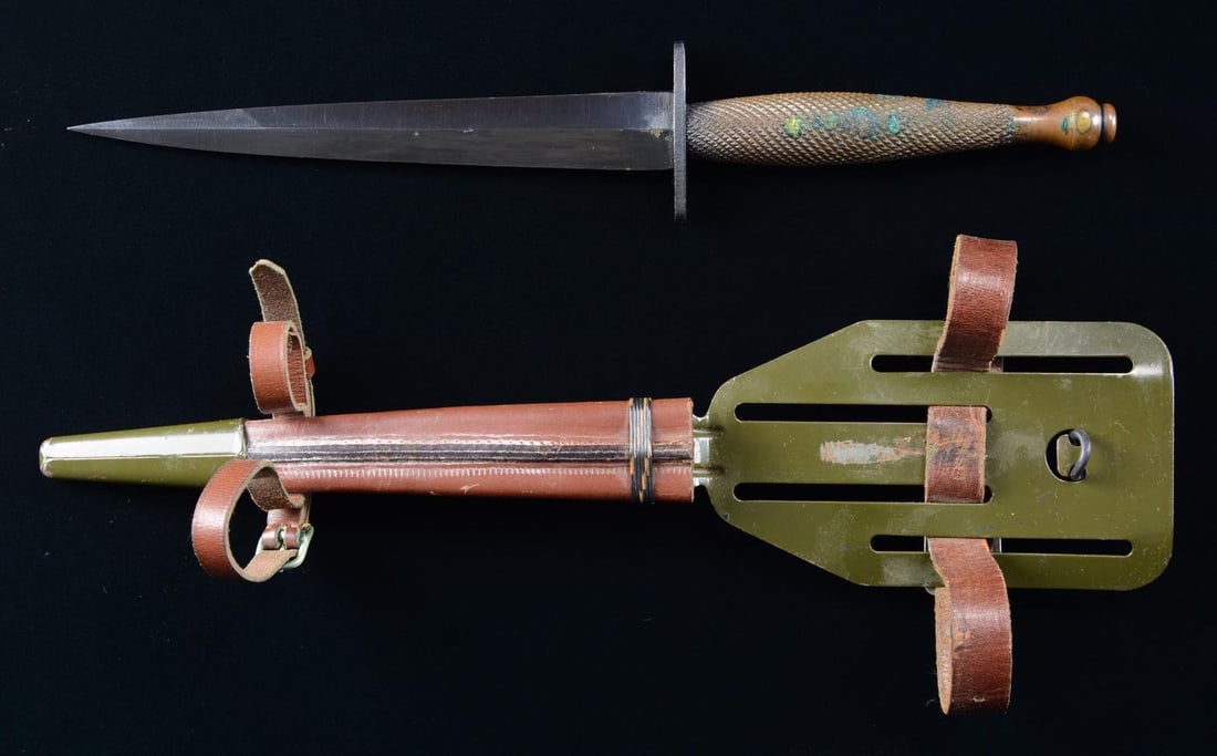 SCARCE OSS COMMANDO FIGHT KNIFE WITH "PANCAKE: FLIPPER" SCABBARD. Overall length: 11 1/2". Blade length: 6 5/8". Unmarked blued blade and guard with coarse knurled brass grip. OD painted "Pancake Flipper" steel frog with brown leather scabbard and