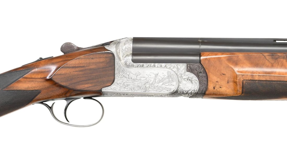 PERAZZI MX-8 WITH SEMI RELIEF GAME SCENE ENGRAVING: . Cal. 12 Ga. 2-3/4". S# 33298 (1968). The 26" mono-bloc barrels are fitted with matted ventilated rib and are ported. Maker's name and address are on top left of mono-bloc. Bottom of mono-block is st