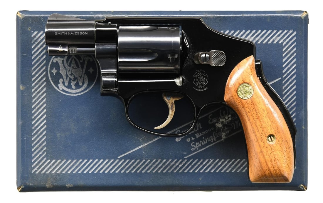 SMITH & WESSON MODEL 42 AIRWEIGHT DAO REVOLVER.: Cal. 38 Spcl. S# L6669. Bbl. 2" pinned. Ramped blade front sight. Fixed rear sight. DAO revolver w/ grip safety & flat latch. Blue finish. Case colored trigger. Smooth walnut grips w/ S&W medallions.