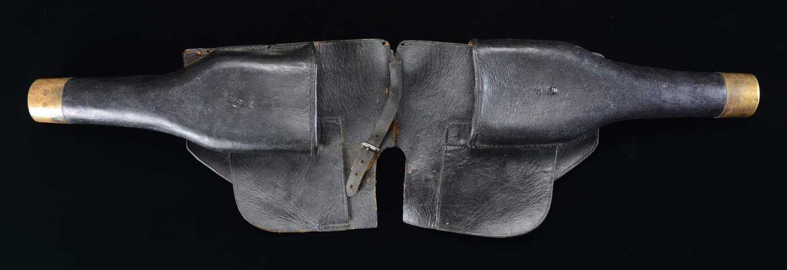 PAIR OF EARLY POMMEL HOLSTERS.: Holsters like this were used to carry pistols on a saddle when on horseback. They are made of black leather with backing pads and holster cups with brass tips. There is a single small iron roller buck