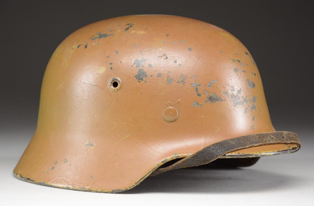 WWII GERMAN M1940 KRIEGSMARINE HELMET WITH TAN: OVERPAINT. An interesting M1940 helmet, which clearly has a Kriegsmarine eagle on the left side but does not appear to have a decal on the right side. The whole helmet has been overpainted in a tropic