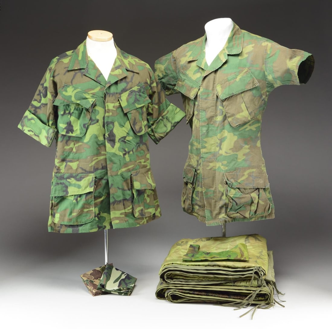 US MILITARY CAMOUFLAGE UNIFORMS & PARTS.: This lot consists of 1 camouflage short sleeve 4-pocket fatigue shirt with a Nha Trang Vietnam label. / 2 Camouflage insulated woobie blankets. / 1 Camouflage short sleeve 4-button fatigue shirt. / 1 