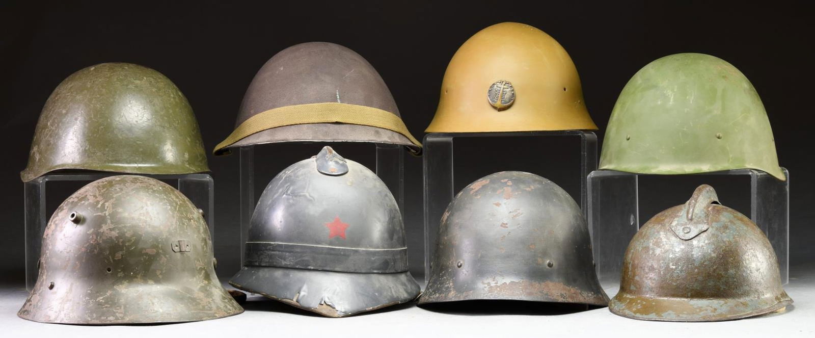 GROUPING OF 8 MISCELLANEOUS FOREIGN MILITARY: HELMETS. 1) Soviet SSh-39 helmet. Green painted finish with wool and leather liner. Liner is faintly marked with what appears to be a partially discernible name "ELINIK". Left side of leather chinstra