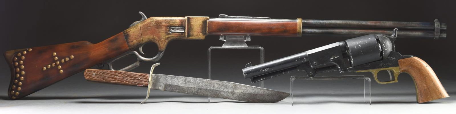 DESIRABLE GROUP OF 3 OVERSIZED RIFLE, REVOLVER,: AND KNIFE STORE DISPLAYS. 1) Wood display of a Winchester Model 1866 lever action rifle. Brass colored frame, buttplate, and rear bbl. band, with brass colored tack decorated butt. CONDITION: very goo