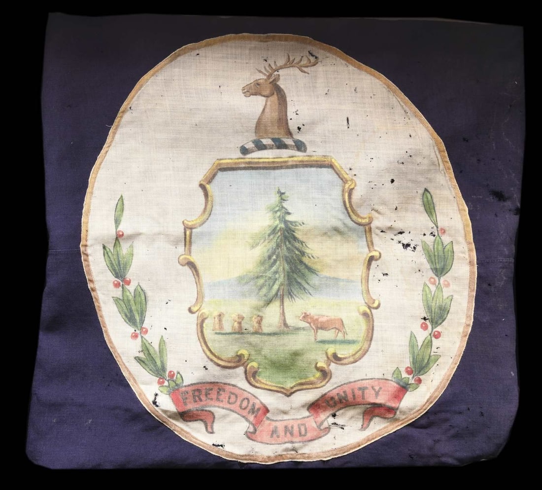 VERMONT STATE FLAG, CIRCA 1920.: 58" x 38" blue bunting with 20" painted central medallion of Vermont state seal with motto "FREEDOM & UNITY". This has to be one of the earliest renditions with the circular medallion when the stripes