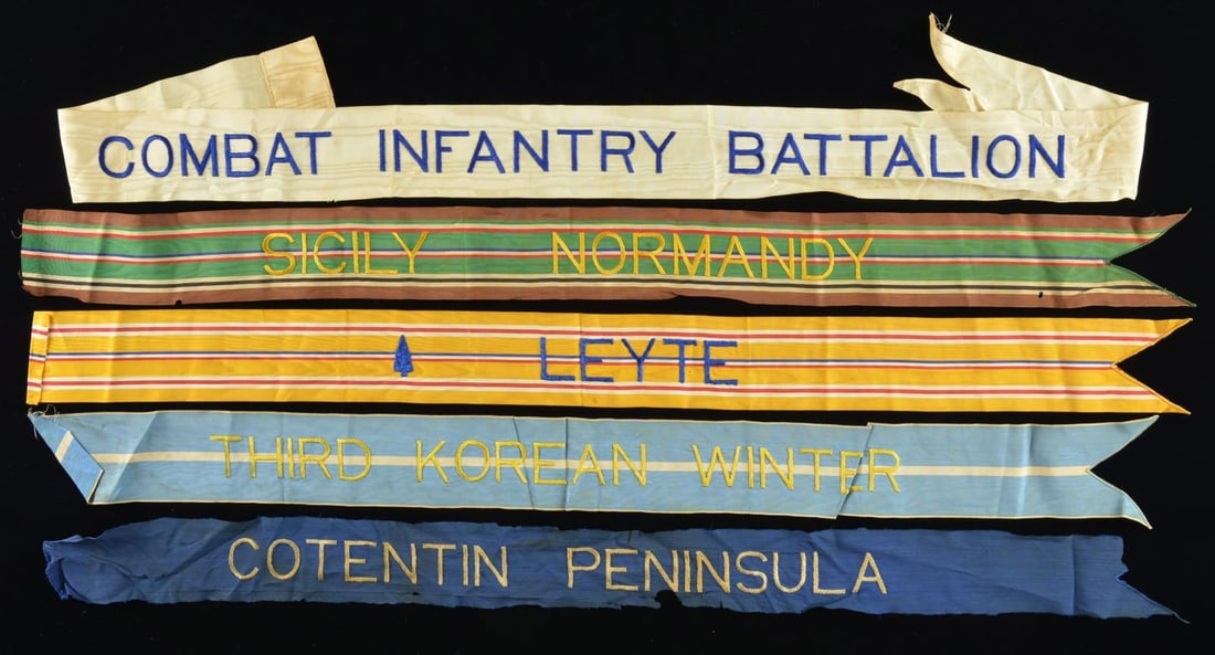 FIVE BATTLE FLAG STREAMERS.: Ranging from 32"-45", WW2 & Korean War, including “LEYTE” with spearhead, “SICILY NORMANDY”, “COTENTIN PENINSULA” (D-Day campaign). CONDITION: fair to good overall, some reduct