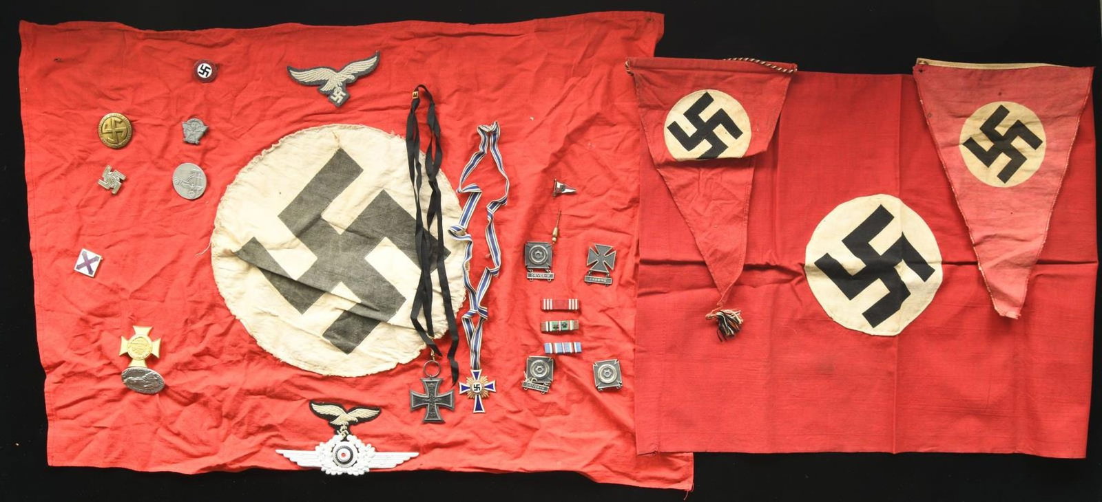 WWII GERMAN FLAGS, PENNANTS & ASSOCIATED MATERIAL.: This lot includes 1 large party flag that measures approx. 96” x 48”. Flag has a printed party symbol on a sewn white circular disc all on a red field. / 1 Small party flag measuring appro