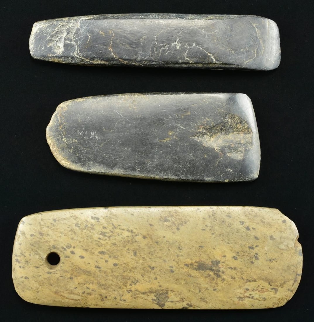 THREE AMERICAN INDIAN POLISHED STONE AXES.: Polished stone Native American cutting tools measuring from 5.5" to 8", the largest has a hole cut at top. CONDITION: very good overall with chips as can be seen in photos. PROVENANCE: From the Lifelo