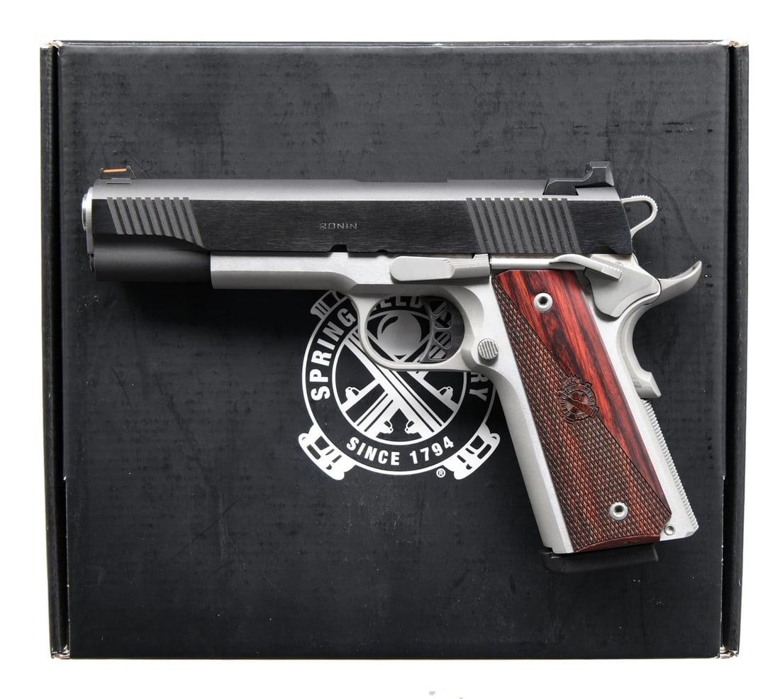 SPRINGFIELD ARMORY 1911 RONIN SEMI AUTO PISTOL.: Cal. 45 ACP. S# NM776421. Bbl. 5". Fiber optic front sight. White dot rear sight. Blued slide. Stainless frame. Extended beavertail grip safety. Extended right hand safety. Checkered wood grips w/ Spr