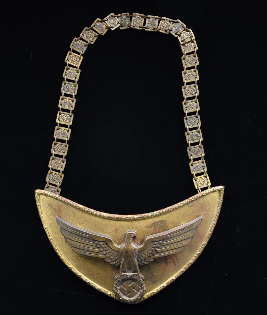 WWII GERMAN NSDAP STANDARD BEARER’S GORGET.: A fine original example of one of the more attractive gorgets of WWII Germany. The gold-plated gorget has a large central party eagle, with a wingspan of over 7”, perched on a wreath surrounding