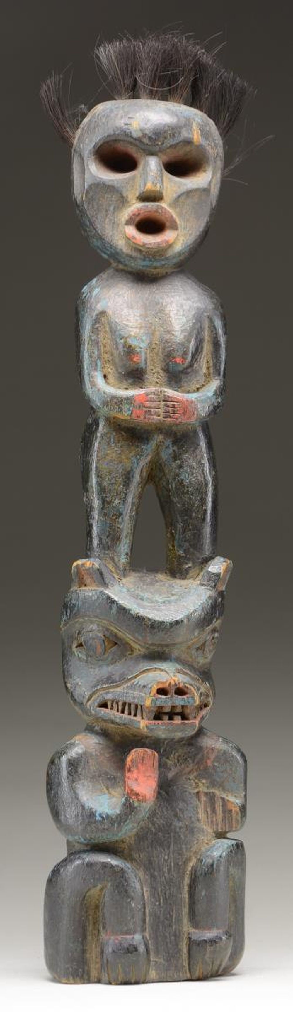 SMALL CARVED TOTEM.: This small carved, possibly vintage totem of unknown origin measures 18" in height, including the hair. The totem is trimmed with red & blue painted highlights. CONDITION: good overall condition, with
