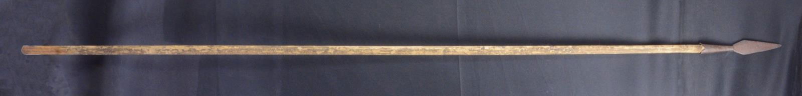 TRENCH SPEAR OR NATIVE AMERICAN SPEAR.: Overall length of 93” w/ a 10” head. The iron spear head has a conical base that is held to the wooden shaft by a single nail. Wooden shaft appears to be a soft wood & is faceted in sectio