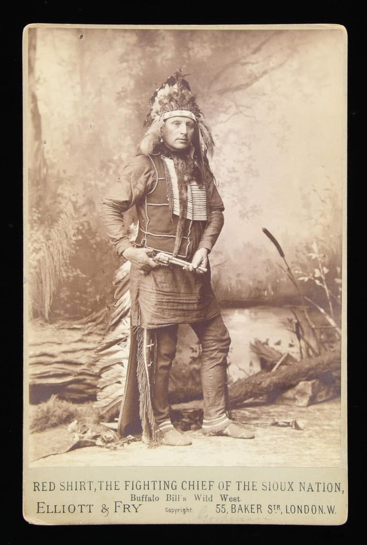 FINE CABINET CARD PHOTO "RED SHIRT, THE FIGHTING: CHIEF OF THE SIOUX" HOLDING COLT SAA REVOLVER. Red Shirt was part of Buffalo Bill's Wild West, touring in England in 1887 where this photo taken by London photographer. CONDITION: very good. PROVENANC