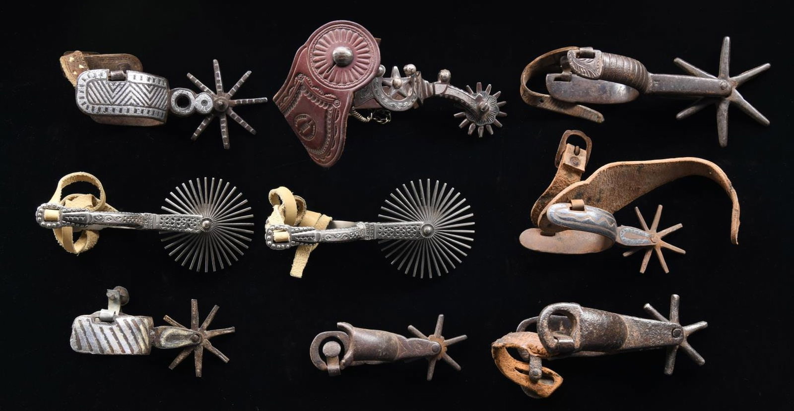 GROUPING OF WESTERN & MEXICAN SPURS.: 9 large rowel spurs, only two are paired, one of the singles is "E. GARCIA" maker marked with Kalispell Mont leather strap. CONDITION: very good overall, iron patina. PROVENANCE: Martin Lane Historic 