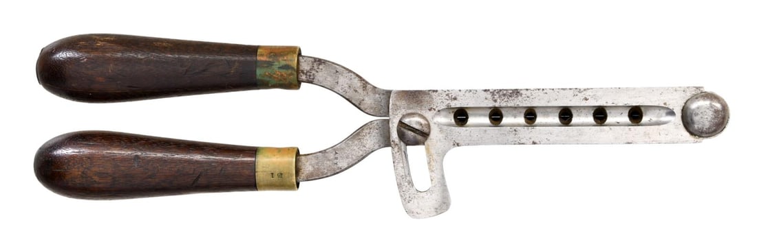 SIX-CAVITY GANG MOLD FOR A 44 CAL. REVOLVER.: This mold was likely for a Colt 1860 Army 44-cal. revolver. It measures 12 3/4" overall and is primarily made of iron. It casts six conical miniball bullets in one pour. The mold is marked near the to