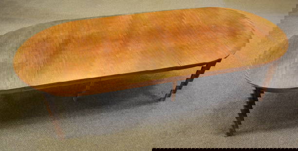 SWEDISH KARL ANDERSON TEAK DINING TABLE.: Mid 20th Century. The solid oval top projected above a straight apron, raised on four tapering oval legs and a central pair of central supports with metal braces for use when table is fully extended.