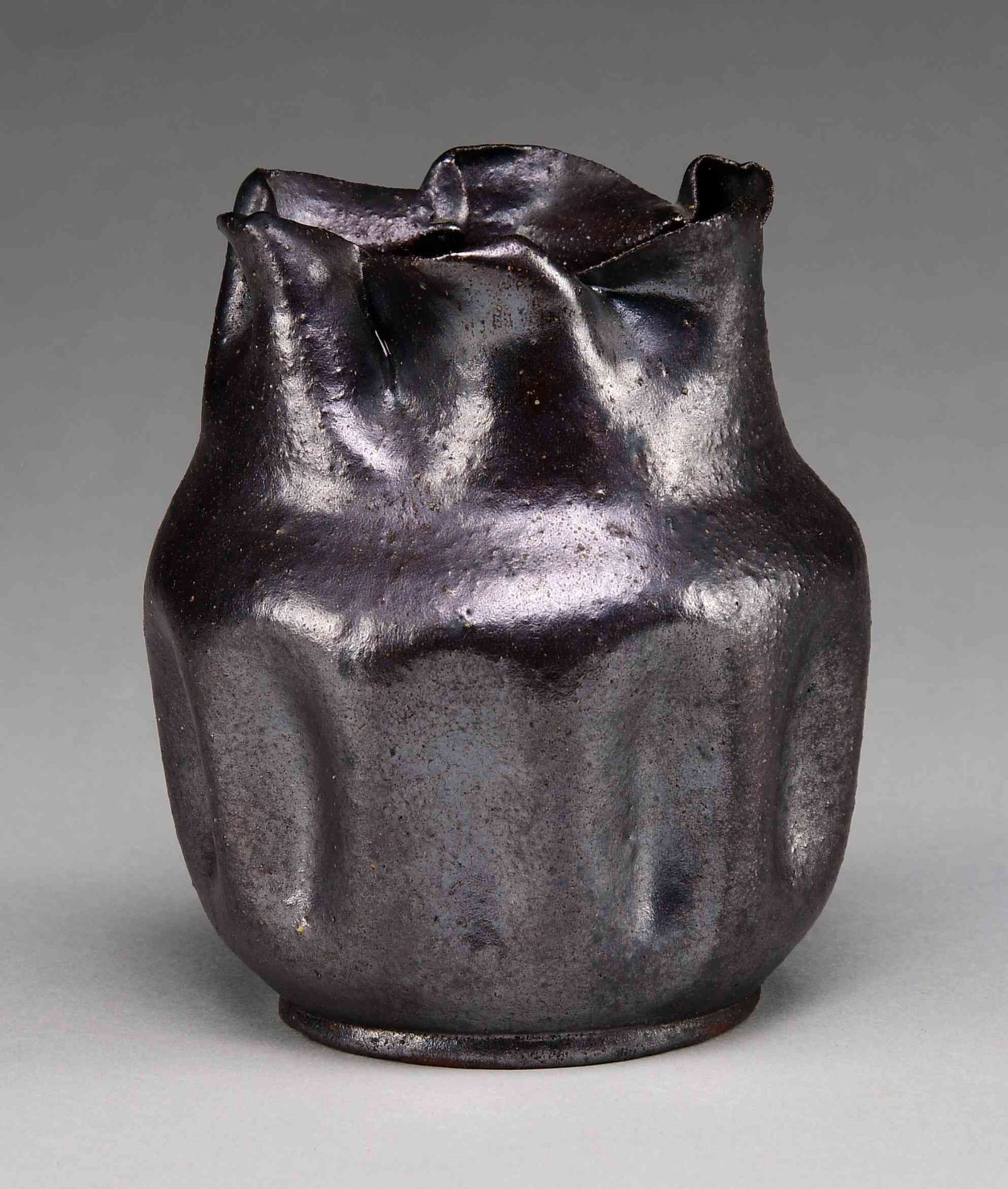 BILOXI, MISSISSIPPI BROWN GLAZE VASE.: Vase in the manner of George Ohr with vertical dimples around the circumference of the vase. The rippled neck of uneven proportions. Glaze finish appears to have a slight iridescence. Scratched on the