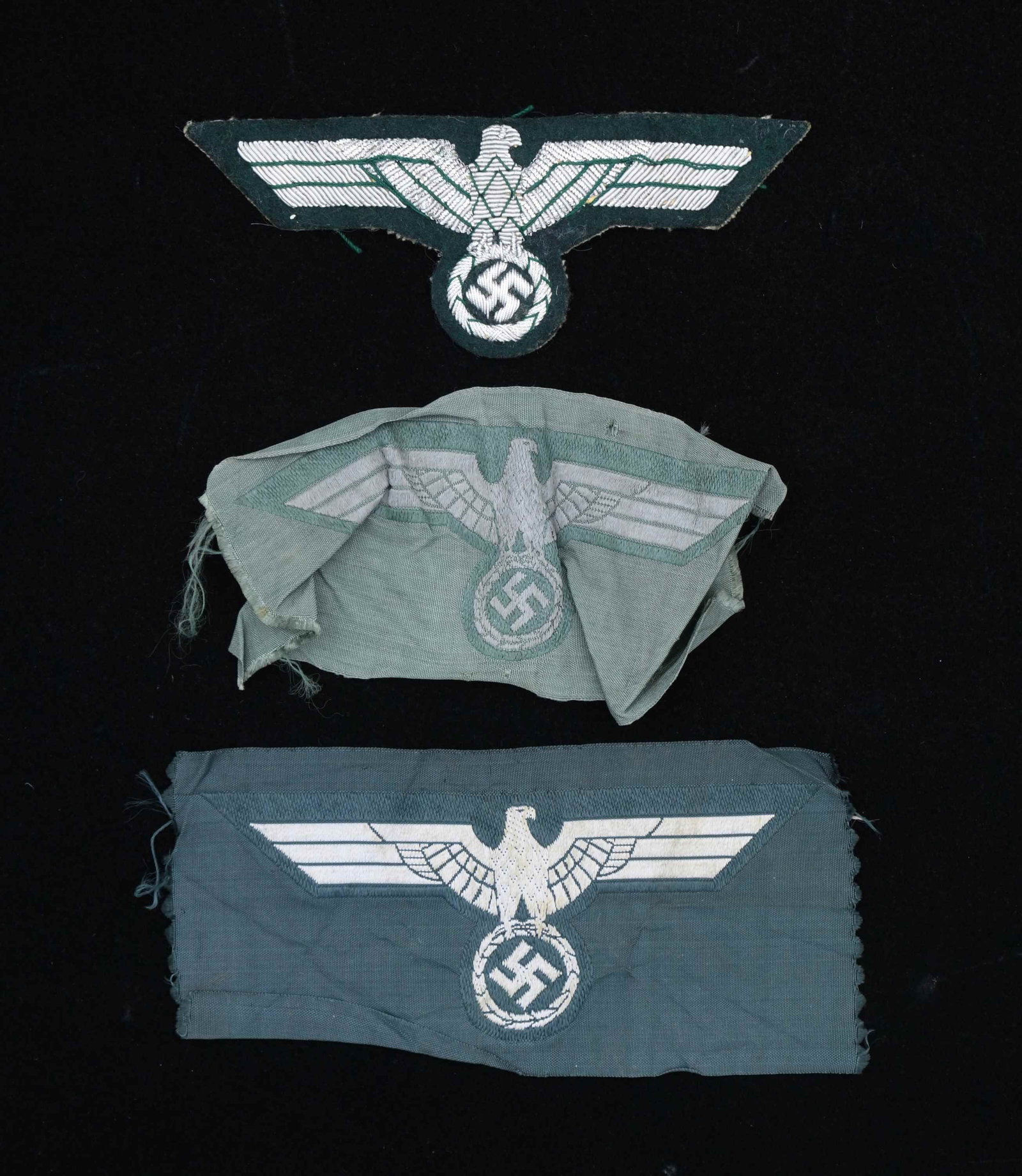 3 WWII GERMAN BREAST EAGLES.: This lot includes 1 Panzer officer's silver bullion breast eagle with a black wool front and green cotton reverse. / 1 Panzer enlisted Bevo-weave breast eagle on black. / 1 Wehrmacht enlisted Bevo-wea