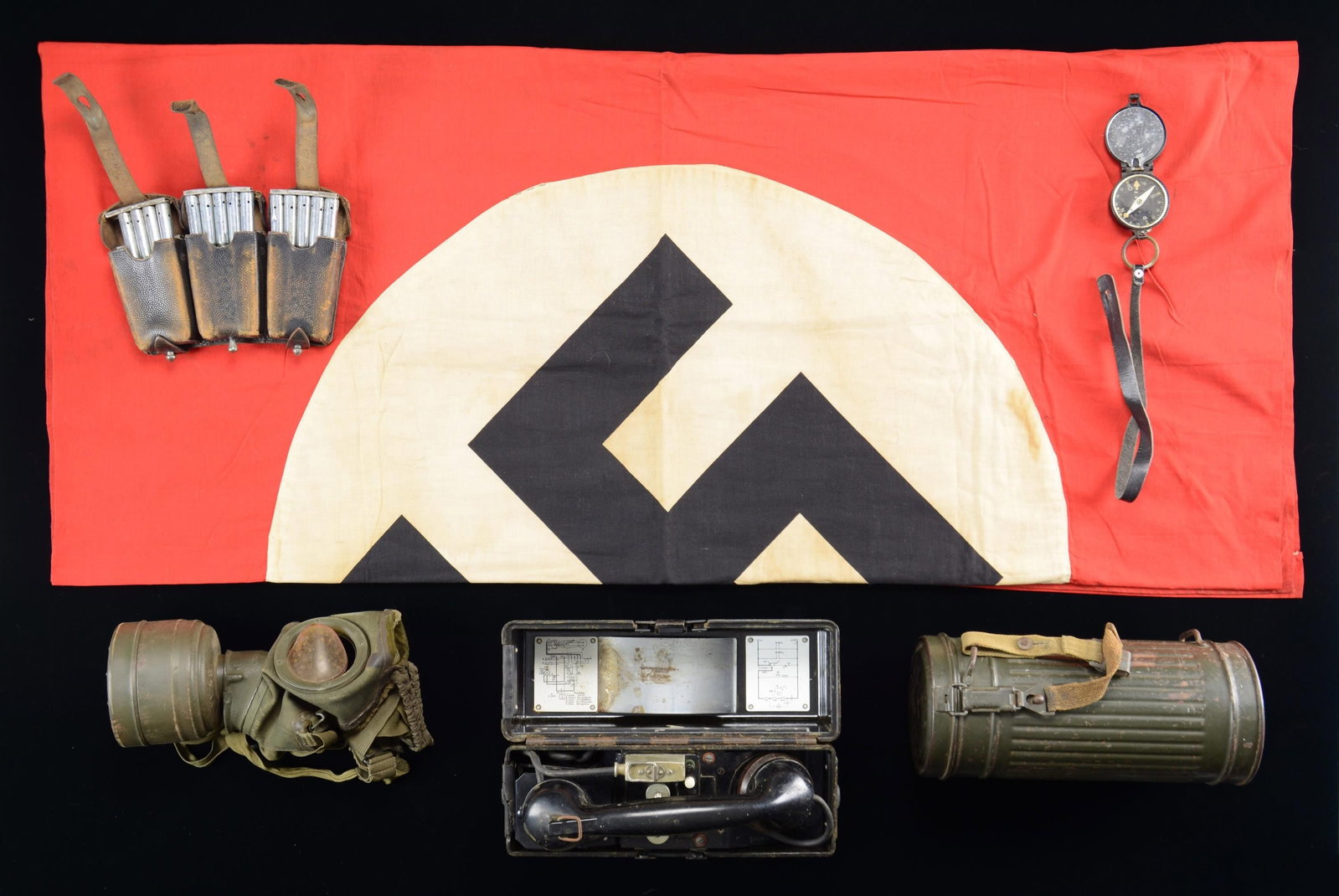 WWII GERMAN FIELD PHONE, FLAG, COMPASS, GASMASK, &: AMMO POUCH. This lot includes 1 self-contained WWII German field phone measuring approx. 10 3/4" x 3 1/2" x 8 1/2" tall. It is a Bakelite box housing a field phone with two connecting terminals on the