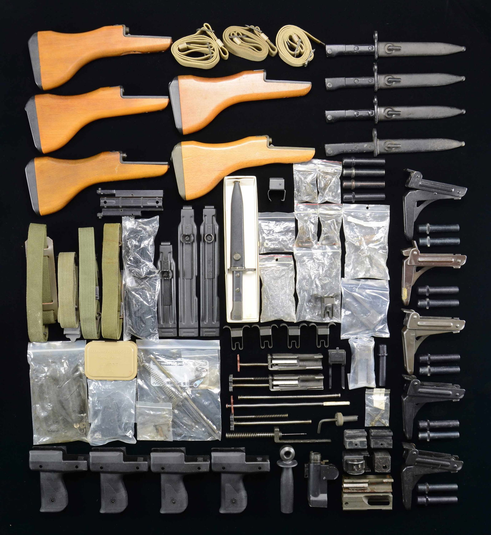LARGE LOT OF UZI PARTS, HARDWARE & ACCESSORIES.: Large grouping of Uzi parts & accessories including the following: 5 folding shoulder stocks, 5 hardwood shoulder stocks, 5 original bayonets, 9 Mini-Uzi bolts, 1 Uzi Carbine bolt, 1 Uzi SMG bolt, 2 c