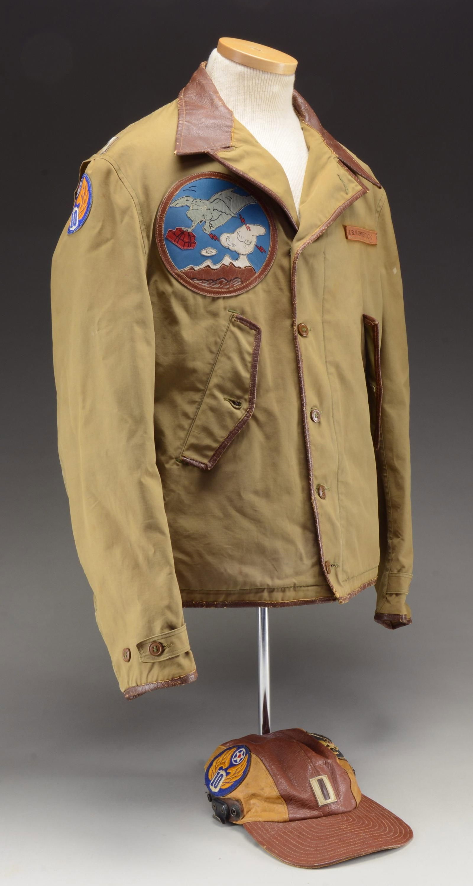 A RARE & EXTRAORDINARY CBI 10th AIR FORCE FLYING: TIGERS FLIGHT JACKET & CAP. A truly superb early WWII greenish khaki cotton poplin flight jacket with a brown leather collar. There is brown leather trim down the front, across the bottom, around the 