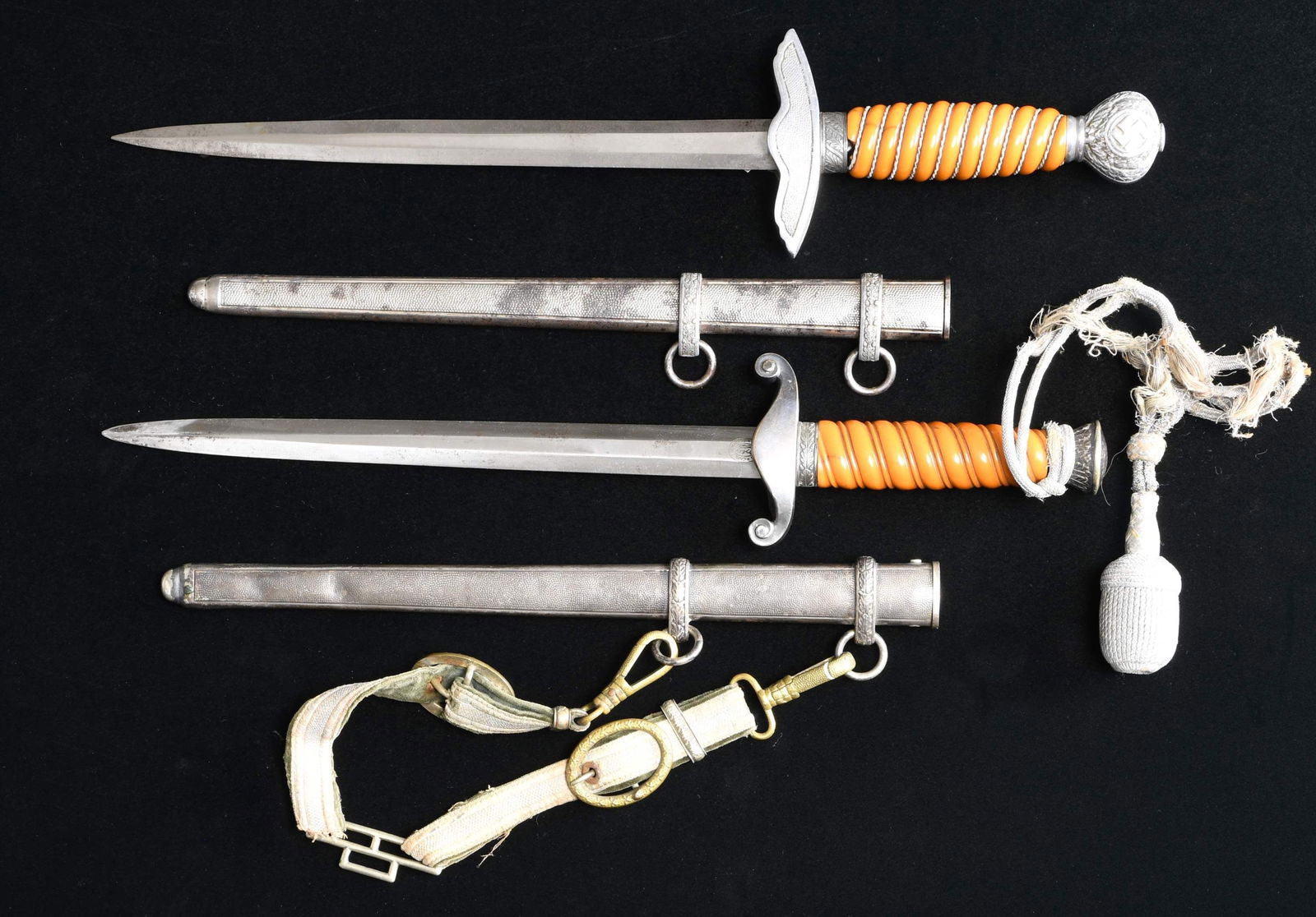 2 WWII GERMAN DAGGERS.: 1) ARMY. Overall length: 15 5/8". Plain blade marked on the reverse "CARL EICKHORN (logo) SOLINGEN". Plated eagle crossguard with oak leaf embellished pommel and ferrule, Orange composite grip with co