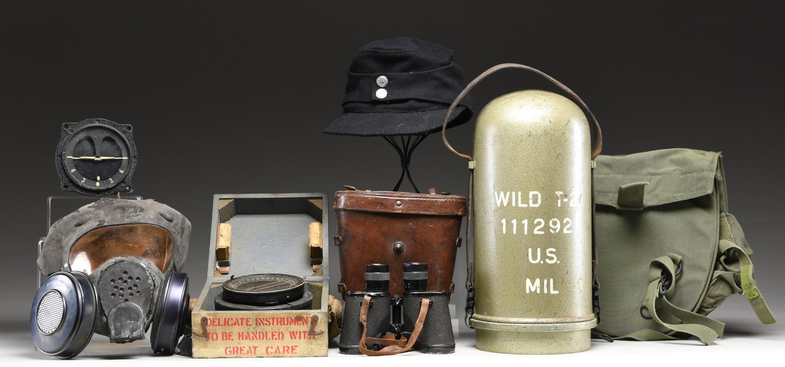 VARIOUS MILITARY INSTURMENTS, GASMASK, BINOCULARS,: AND MORE. This varied lot includes 1 / T2 survey device marked on its metal case "WILD T-2 111292 U.S. MIL". The apparatus inside reads "FSN 6675-988-5225 CONTR DAAE-13-67-C-0687" & "WILD HEEBRUGG SWI