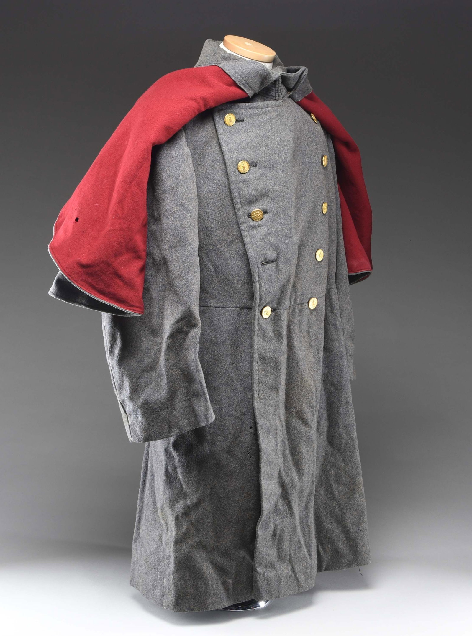 VIRGINIA MILITARY INSTITUTE OVERCOAT WITH CAPE.: This very heavy VMI overcoat likely dates to the WWI era or shortly after. It is created of cadet gray wool with a deep red wool lining on the cape. The front of the cape has two rows of 5 WWI era VMI