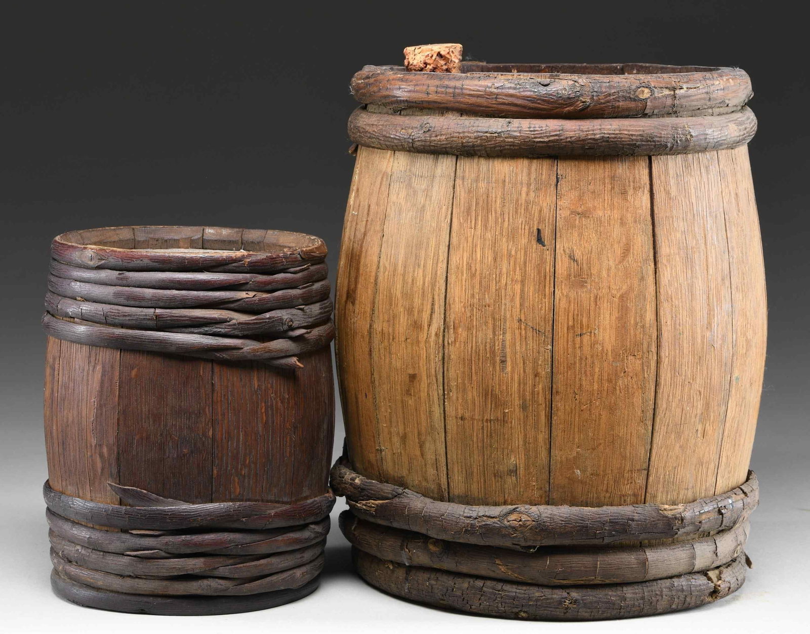 2 WOODEN GUNPOWDER KEGS.: 1) King's Great Western Mining powder keg. Keg measures approx. 12.5" height with 10" diameter at lids. Top lid has paper label & cork cap. Keg has wooden wrappings around top & bottom. 2) Wooden keg.