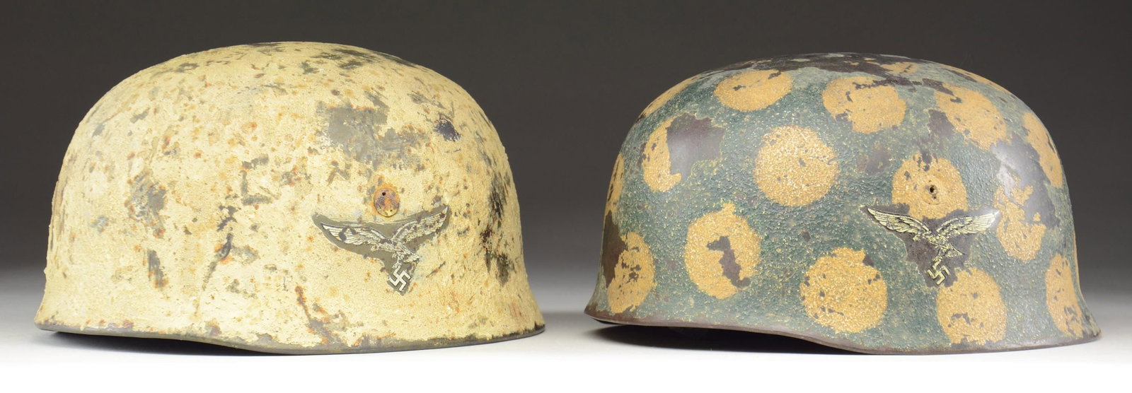 2 M1938 FALLSCHIRMJAGER HELMETS WITH QUALITY: RESTORATION. 1) A fallschirmjager helmet with a painted finish that is extremely thick textured white camouflage. This double decal helmet has a Luftwaffe eagle on the left paired with the National co