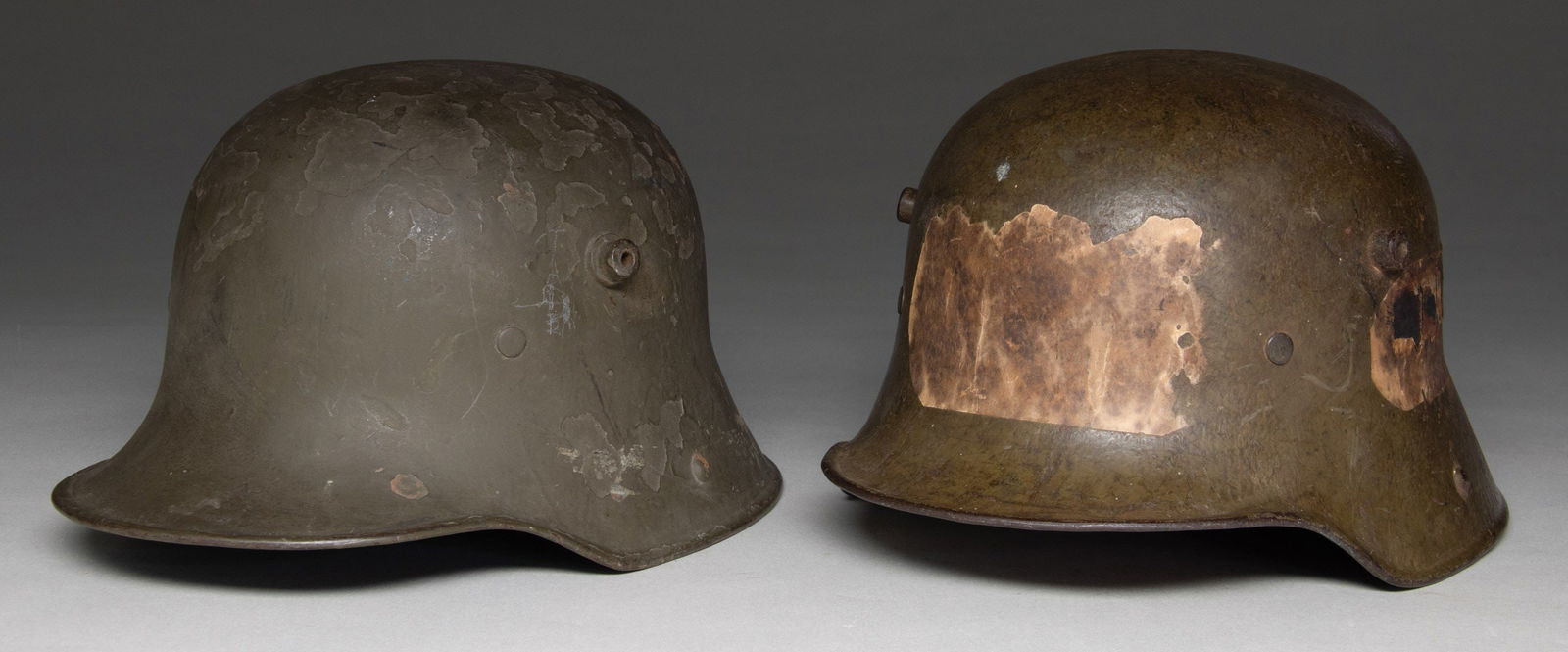 2 WWI GERMAN M17 STEEL HELMETS.: 1) Personalized with a white painted L. Fitz 8/109 on the inside rim. Factory marked ET66. Leather liner and padding present. No chin strap. This example was likely a send back from the war with posta