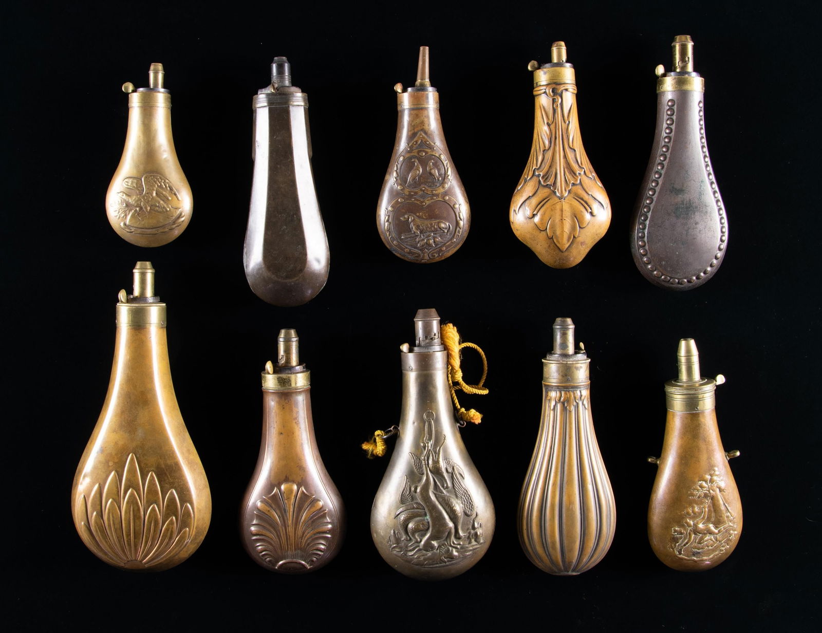 GROUP OF 10 DIFFERENT BRASS RIFLE & SHOTGUN POWDER: FLASKS. All unmarked including 5.5" double sided eagle flask, others measure 6.5" to 9". CONDITION: good to very good overall. PROVENANCE: The Esteemed Norm Greenberg Collection. (02-24848-6/JS). NON-