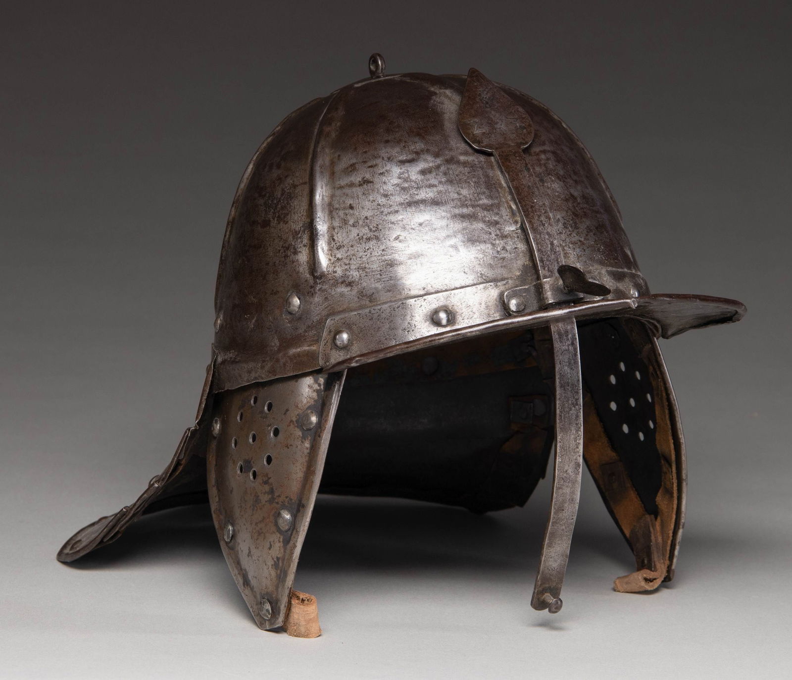 NORTHERN EUROPEAN 1650 LOBSTER TAIL HELMET.: A nice example of a Dutch or German lobster tailed horseman's helmet dating from 1640-1660. It was developed in Europe from a helmet used by the Ottoman Turks in the early 1600s. Characteristically, t