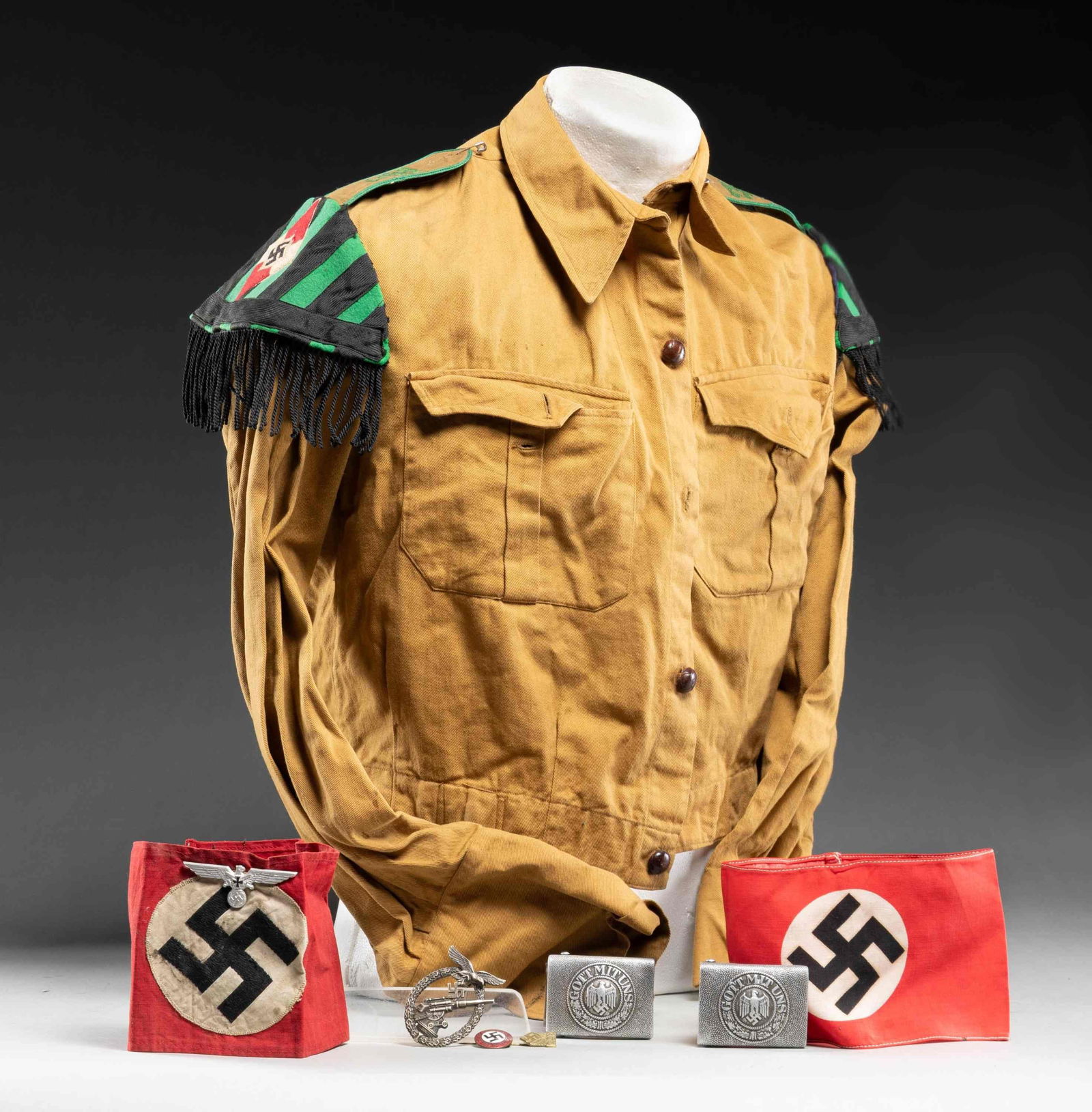WWII GERMAN HJ UNIFORM, ARMBANDS, BADGE & MORE.: This fine group encompasses 1 HJ mustard brown shirt for a musician with leather buttons and shoulder straps that read " 222 II " in green. Each shoulder has a green and black schwalbennest with an em