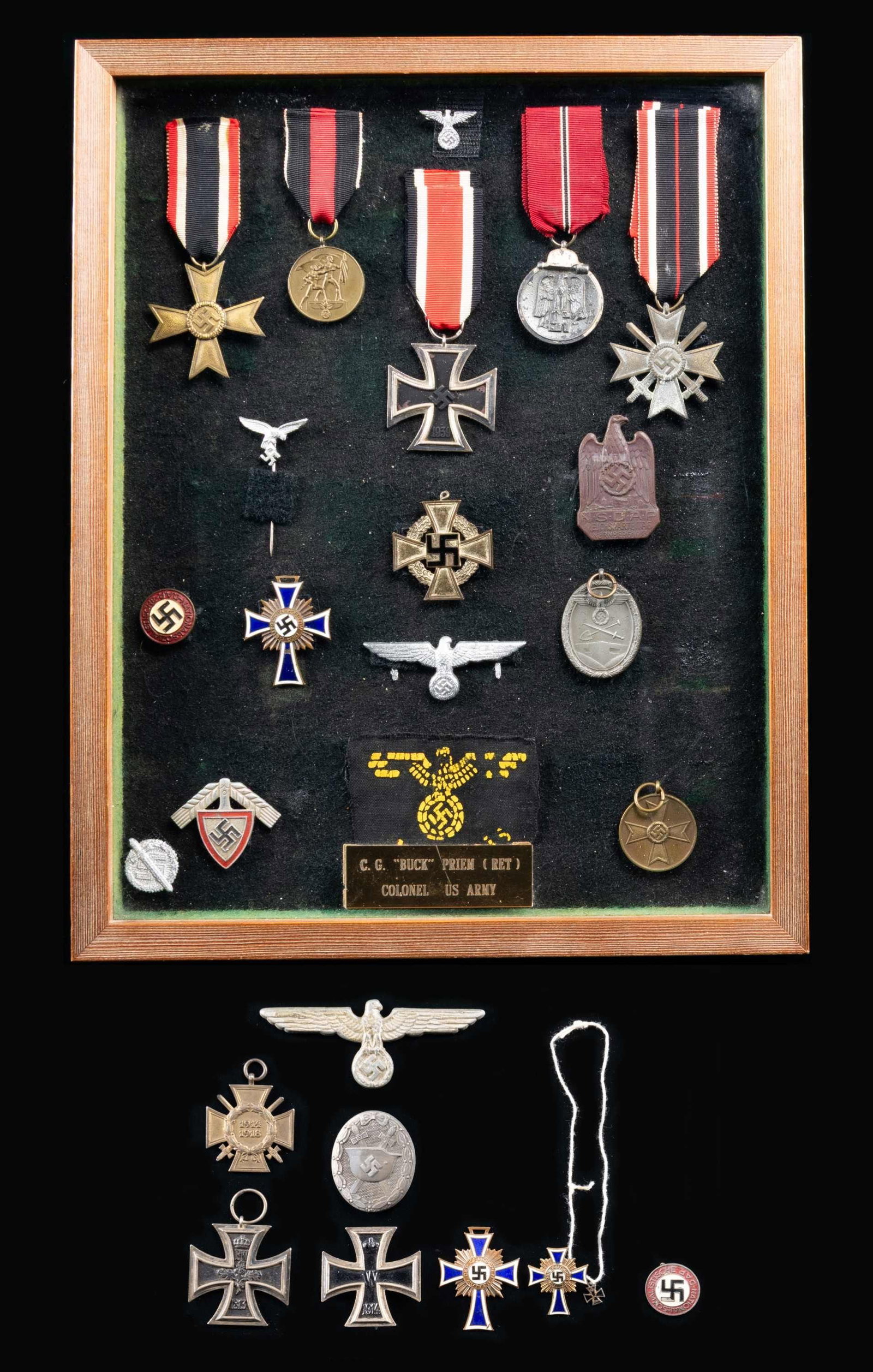WWII GERMAN MEDALS AND PINS.: A large frame containing a group of WWII German medals and pins brought back by Col. C. G. "Buck" Priem. The frame includes 1 War Merit Cross 2nd Class without swords but with ribbon, 1 Sudetenland Me