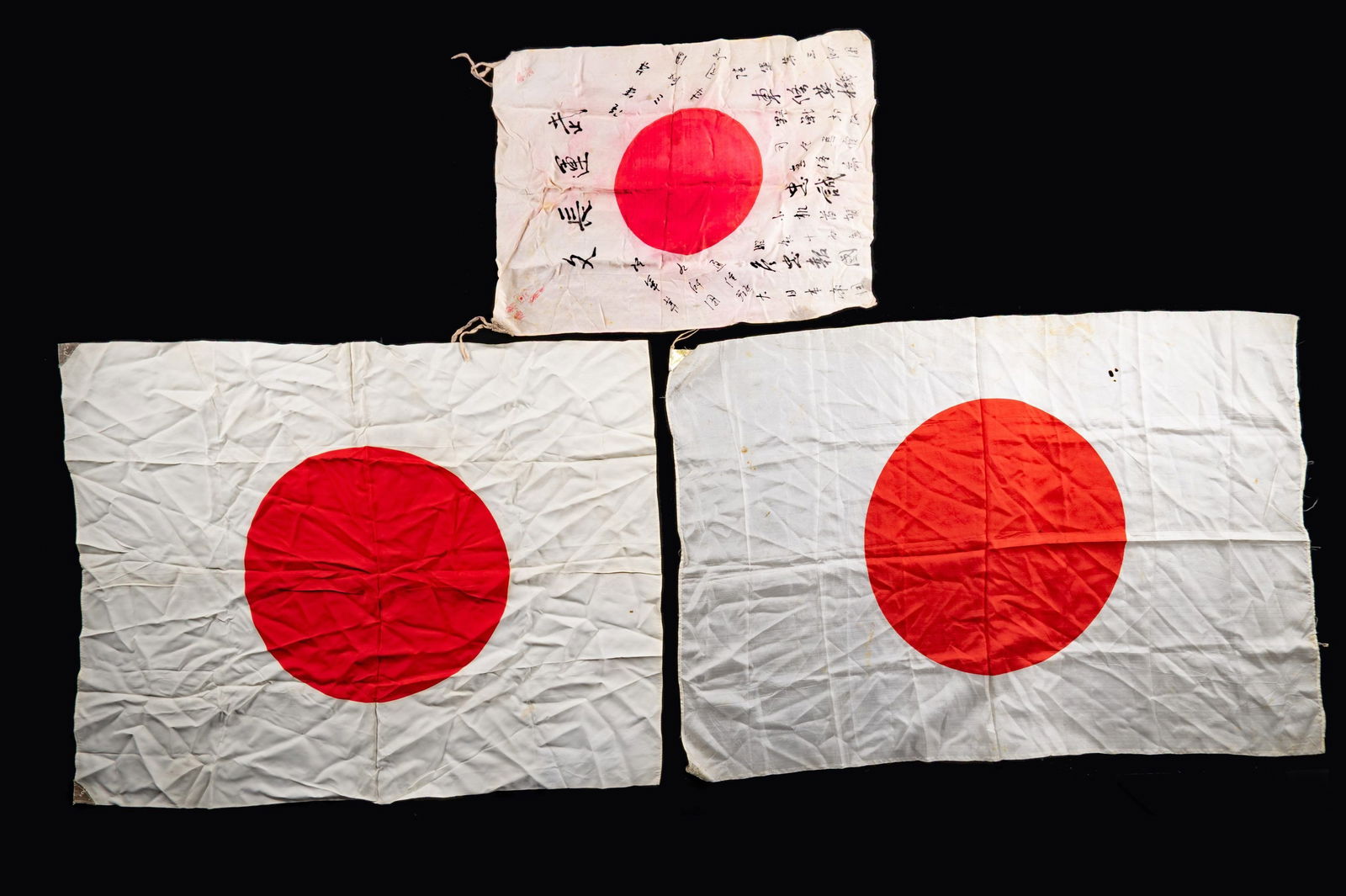 3 WWII JAPANESE HINOMARU SILK FLAGS.: This group includes 1 Nice 36" x 29" Hinomaru flag with reinforced corners. / 1 Good 39' x 28" Hinomaru flag with reinforced corners. / 1 25" x 18" Hinomaru flag with reinforced corners with several J