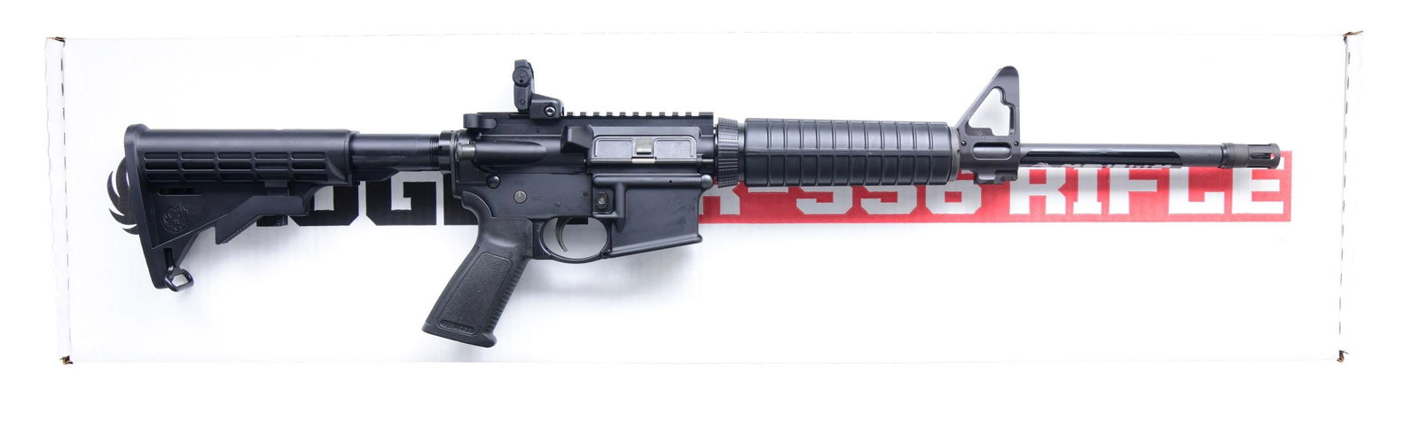 RUGER AR-556 SEMI-AUTO RIFLE WITH MATCHING FACTORY: BOX. Cal. 5.56mm. S# 850-33377 (shipped 2015). This example features a 16-inch barrel with a matte black finish and a standard A2 flash hider. The rifle is equipped with a fixed front sight and a Ruge